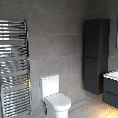 a bathroom with a toilet, sink, and towel rack
